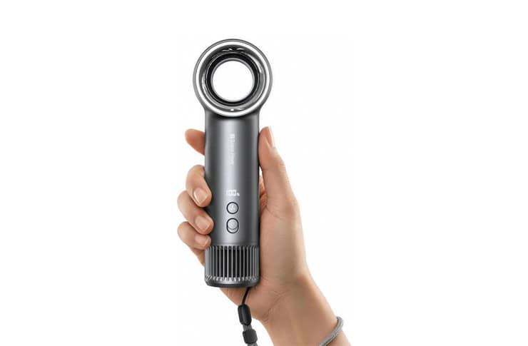 Hand gripping a gray handheld wand-style device with a circular ring nozzle at the top and two control buttons on the body.