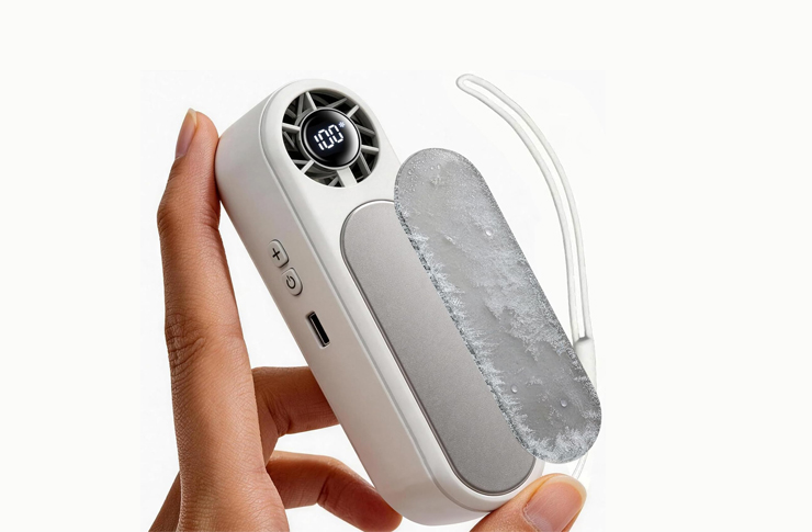 Handheld white personal cooling device with a small fan and digital display, held between fingers.