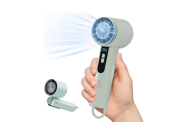 Handheld LED face therapy device emitting blue light, held by a person with a small attachment shown nearby on the side.