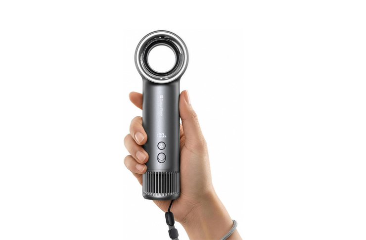 Hand gripping a gray hair styling tool with a circular diffuser/head at the top and two control buttons on the body.