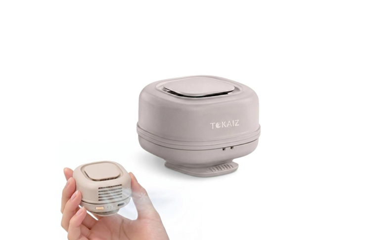 Small handheld electric appliance being held, with a larger matching unit on a white background (compact kitchen gadget).